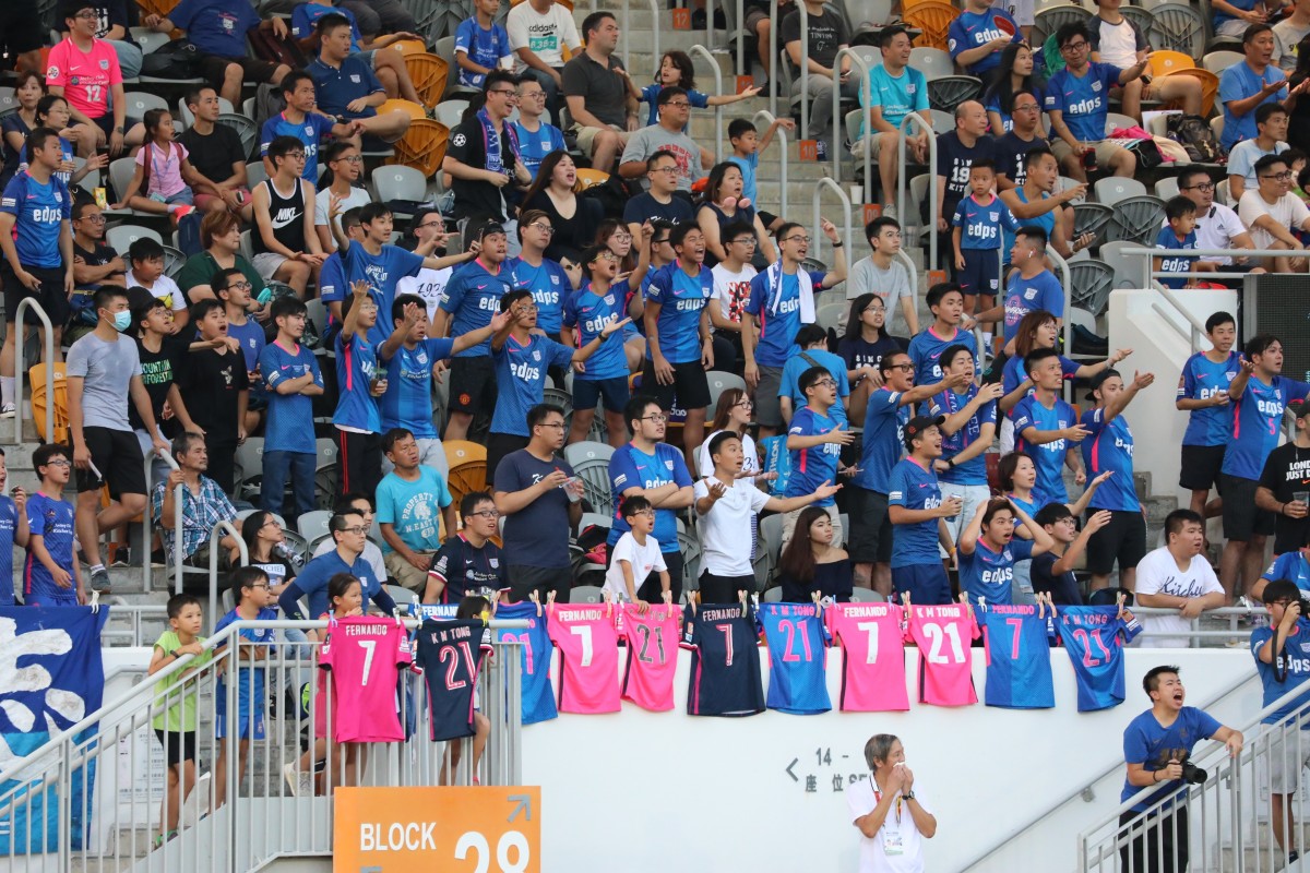 A group of fans chant during the 21st minute of the game between Kitchee and Yuen Long at Mong Kok Stadium. Photo: Felix Wong