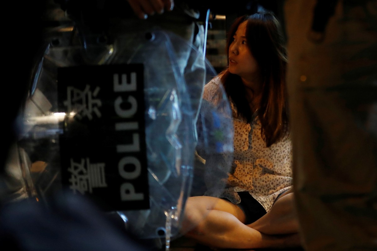 A woman is detained by riot police after Wednesday night’s unrest in Tuen Mun. Photo: Reuters