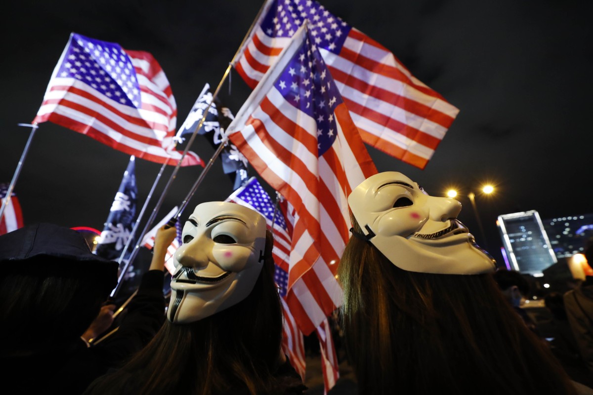Protesters wear masks and hold US flags in Hong Kong on Thursday. Photo: AP