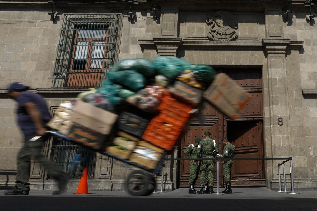 A man pulls a cart full of merchandise past the National Palace. Photo: AP Photo