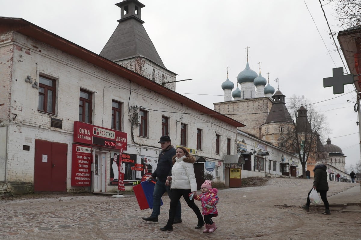 A Russian family walks in front of the monastery in Borisoglebsky, north of Moscow, on a mild and snowless day. Photo: EPA-EFE