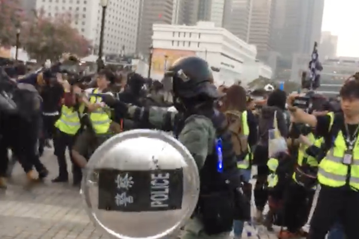 A police officer points his pistol at the crowd at a rally in Central. Photo: Phila Siu