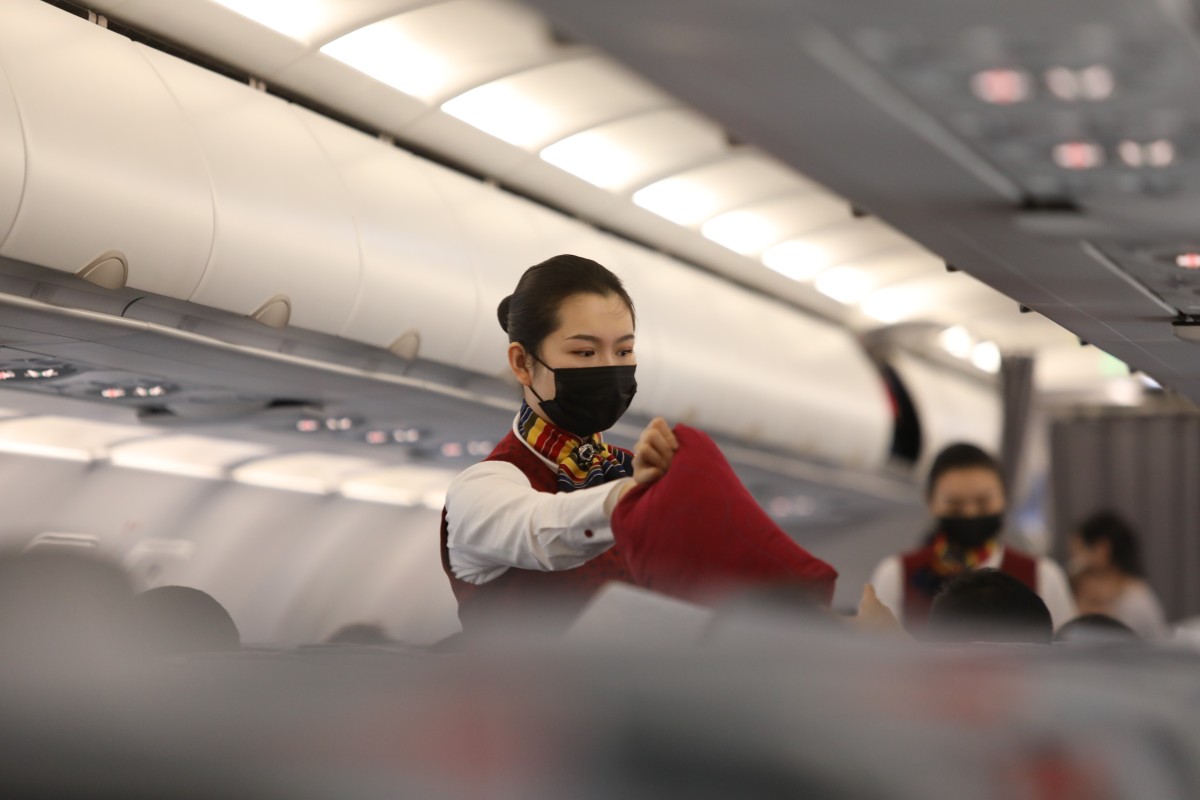 Flight attendants wear masks on a flight from Beijing to Wuhan, the epicentre of an outbreak of a new coronavirus. Photo: Simon Song