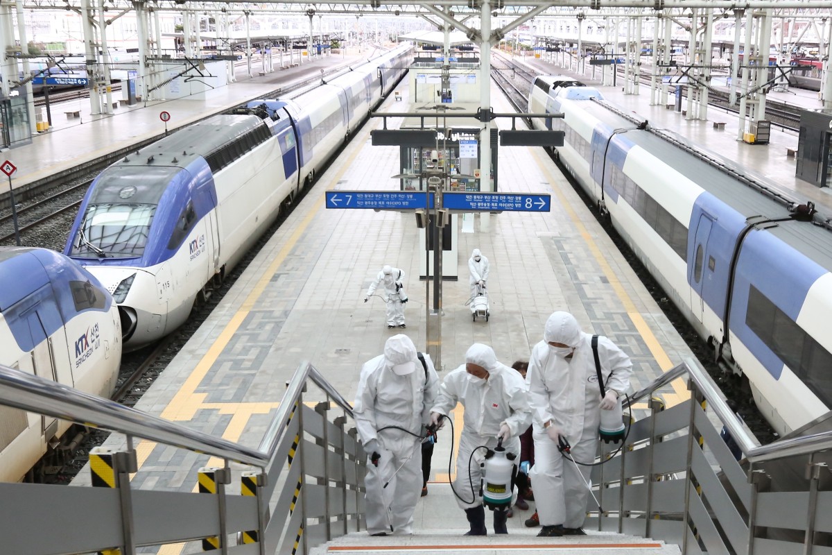 Pekerja menyemprotkan desinfektan di stasiun Seoul.