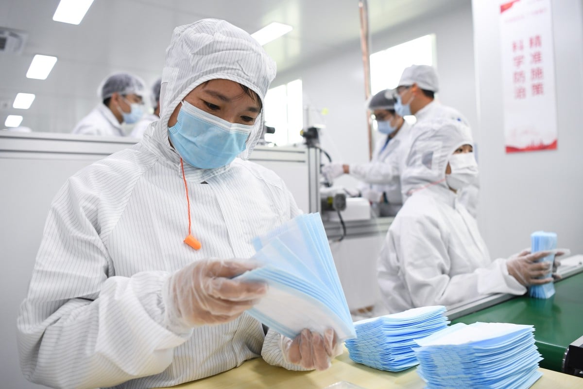Workers are busy on the face mask production line at the GAC Component workshop in Guangzhou in February. Photo: Xinhua