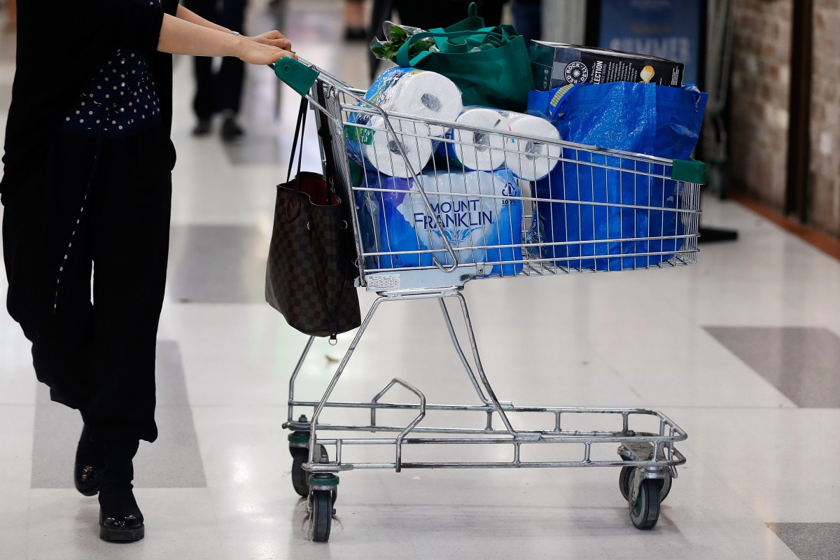 A customer pushes a shopping trolley containing toilet paper at a supermarket in Sydney. Photo: Bloomberg