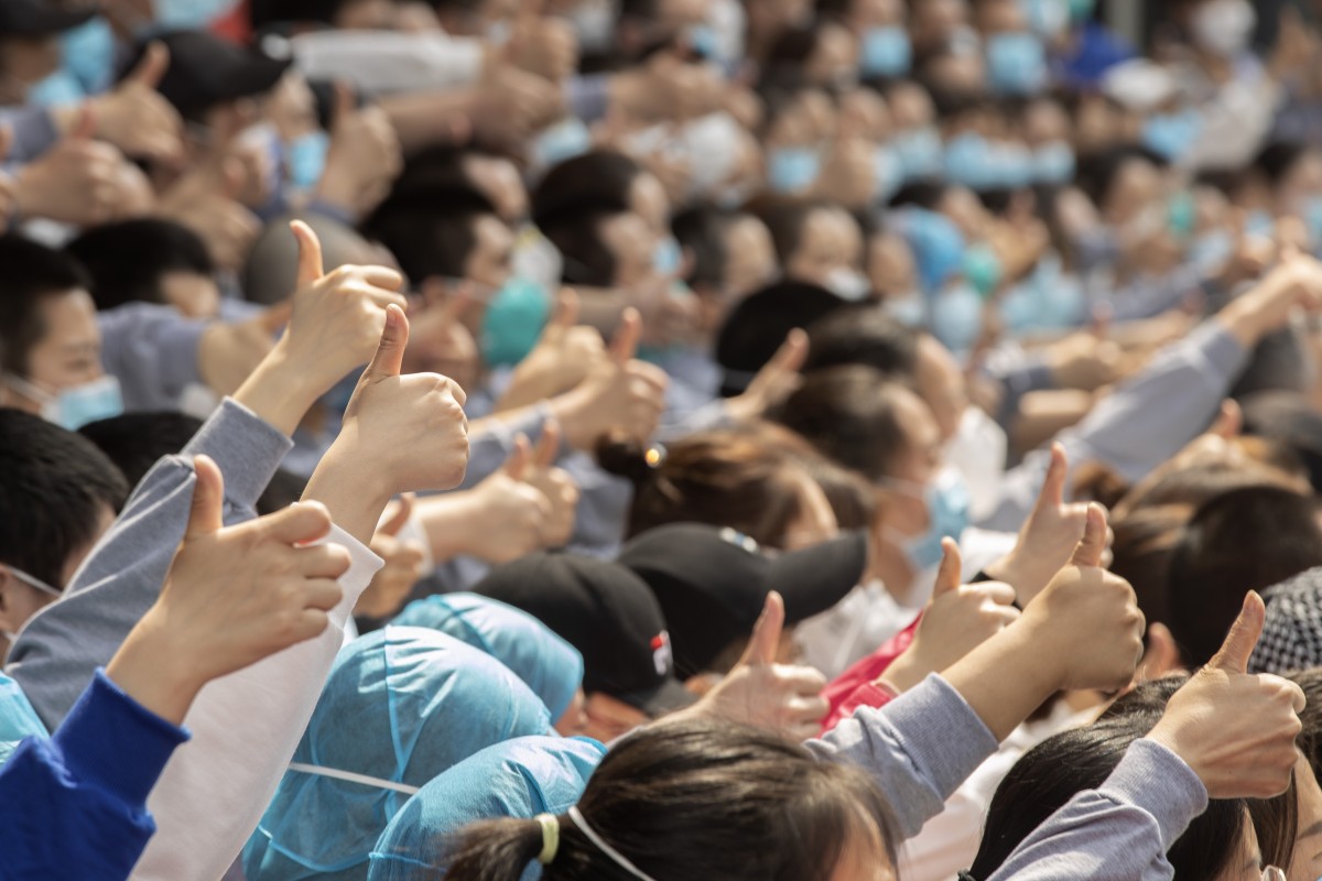 Medical workers from Henan give a thumbs up to Wuhan before leaving the city on Thursday. Wuhan has reported no new cases for a third day. Photo: Xinhua