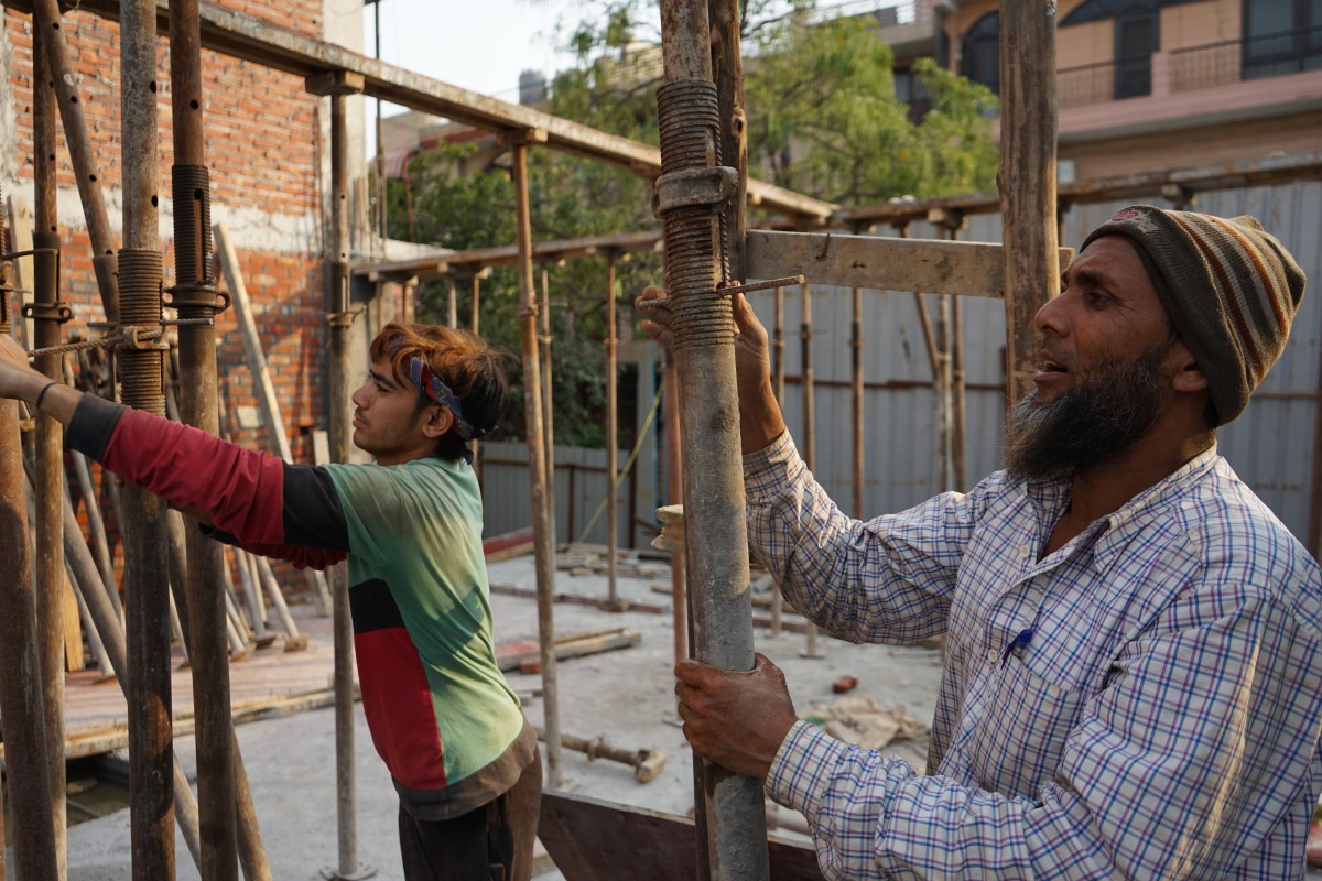 Ajmal Khan (right) at work before he lost his job when the Indian government announced a lockdown to curb the spread of the coronavirus. Photo: Adnan Bhat