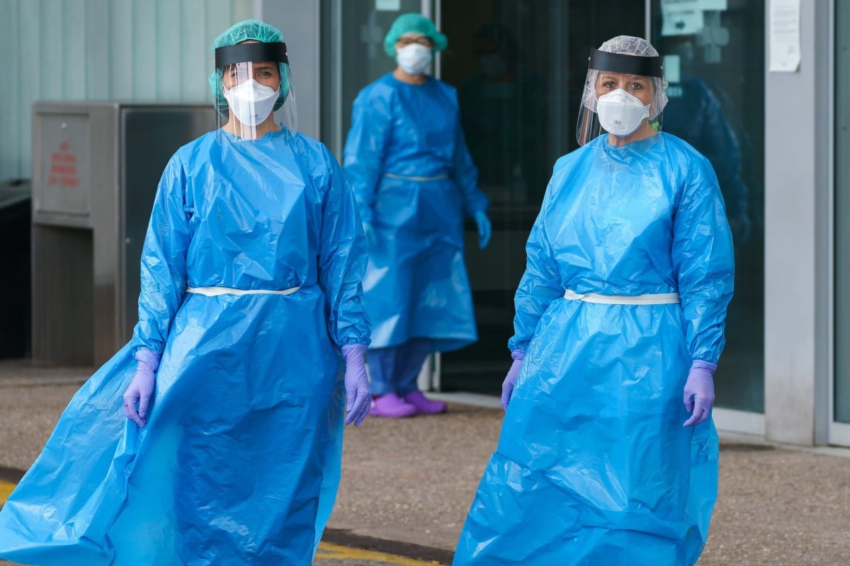 Health workers in protective gear outside an emergency entrance to a hospital in northern Spain. Photo: AFP