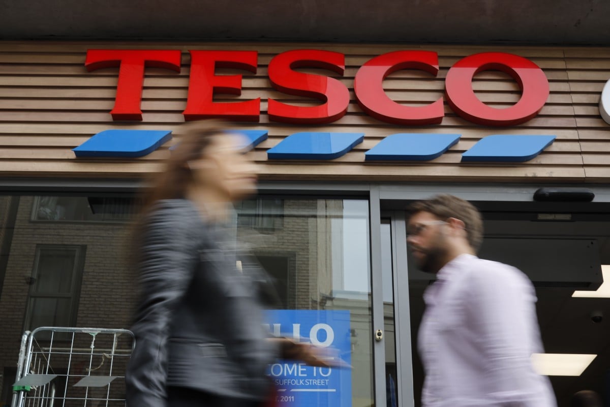 People walk past at a Tesco Express in central London. File photo: AFP