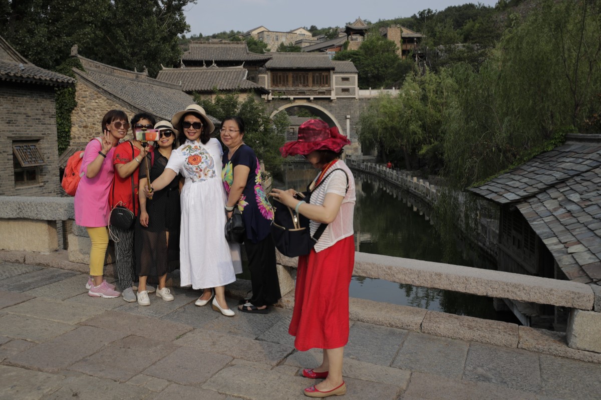 A group of women take a selfie against the ancient village in Gubei Water Town, a popular tourist spot in Beijing, on June 9. Some 59 per cent of mainland Chinese in a recent survey said they worry about travelling now, and a new outbreak of coronavirus has been reported in Beijing. Photo: Associated Press