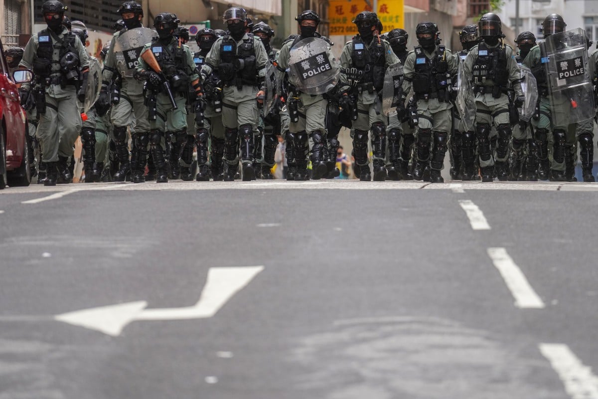 A team of police officers in riot gear stand in formation on a road during a demonstration on the 23rd anniversary of the establishment of the Hong Kong Special Administrative Region (HKSAR) in Wan Chai in July. Photo: Winson Wong