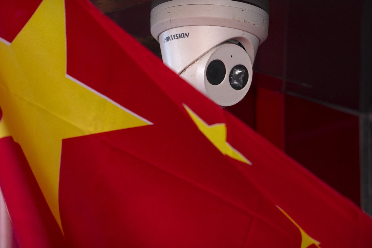 A Chinese flag hangs near a Hikvision security camera outside a shop in Beijing. It is one of the firms the US has blacklisted over its surveillance technology that Washington says is being used to repress Muslim Uygurs in Xinjiang. Photo: AP
