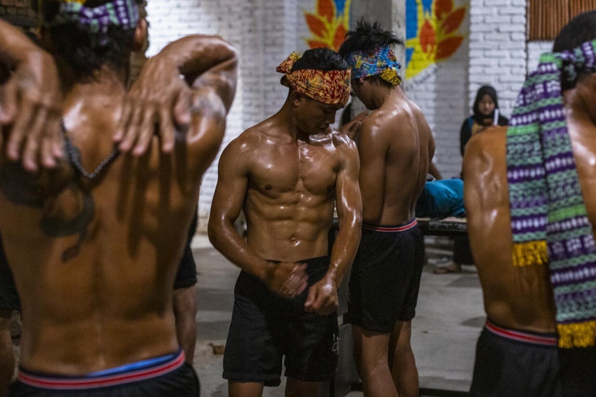 Participants smear their bodies with baby oil in preparation for a bodybuilding contest in Majalengka, West Java, Indonesia. Photo: Agoes Rudianto