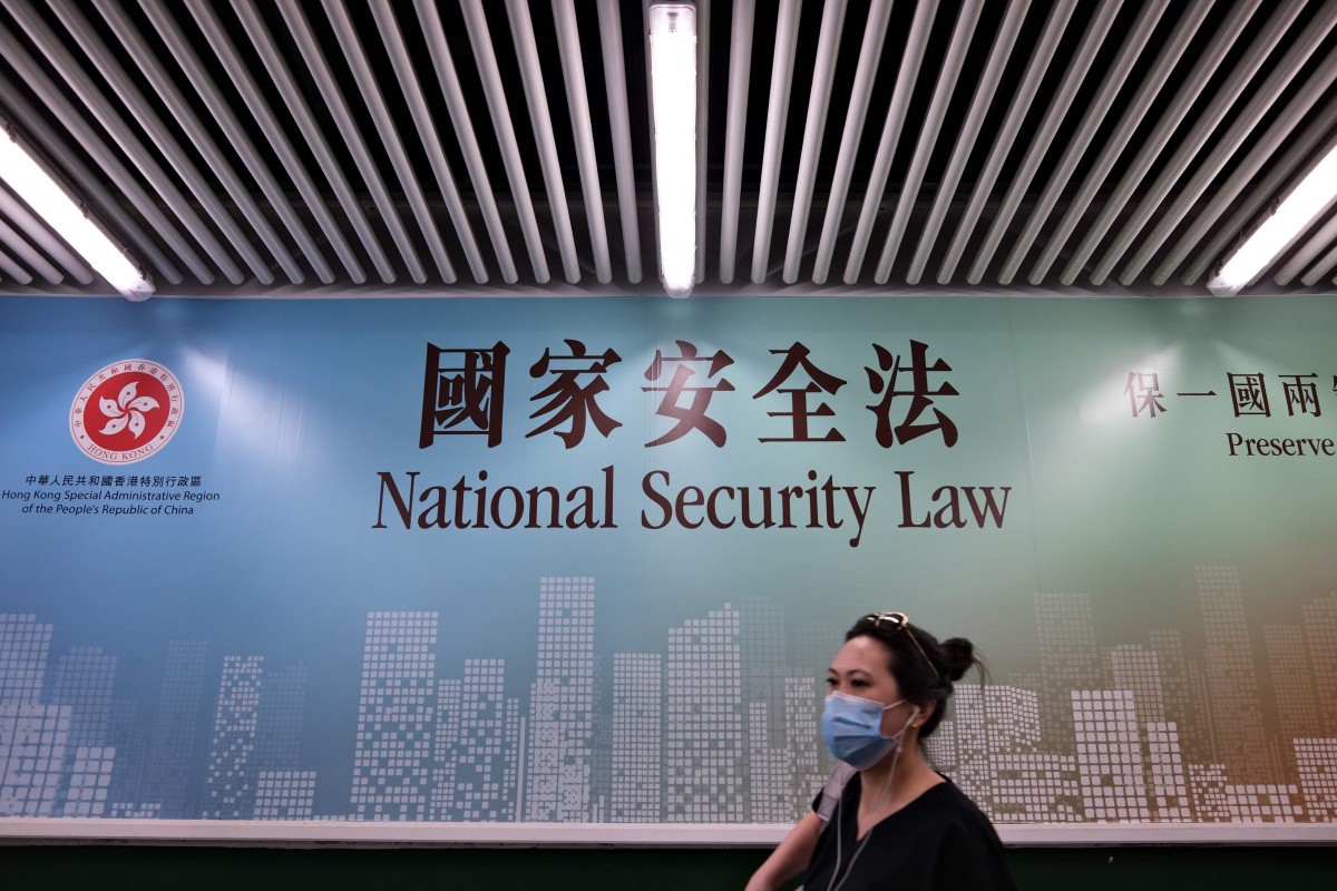A woman walks past a poster for the National Security Law in Hong Kong on July 28. Photo: AFP