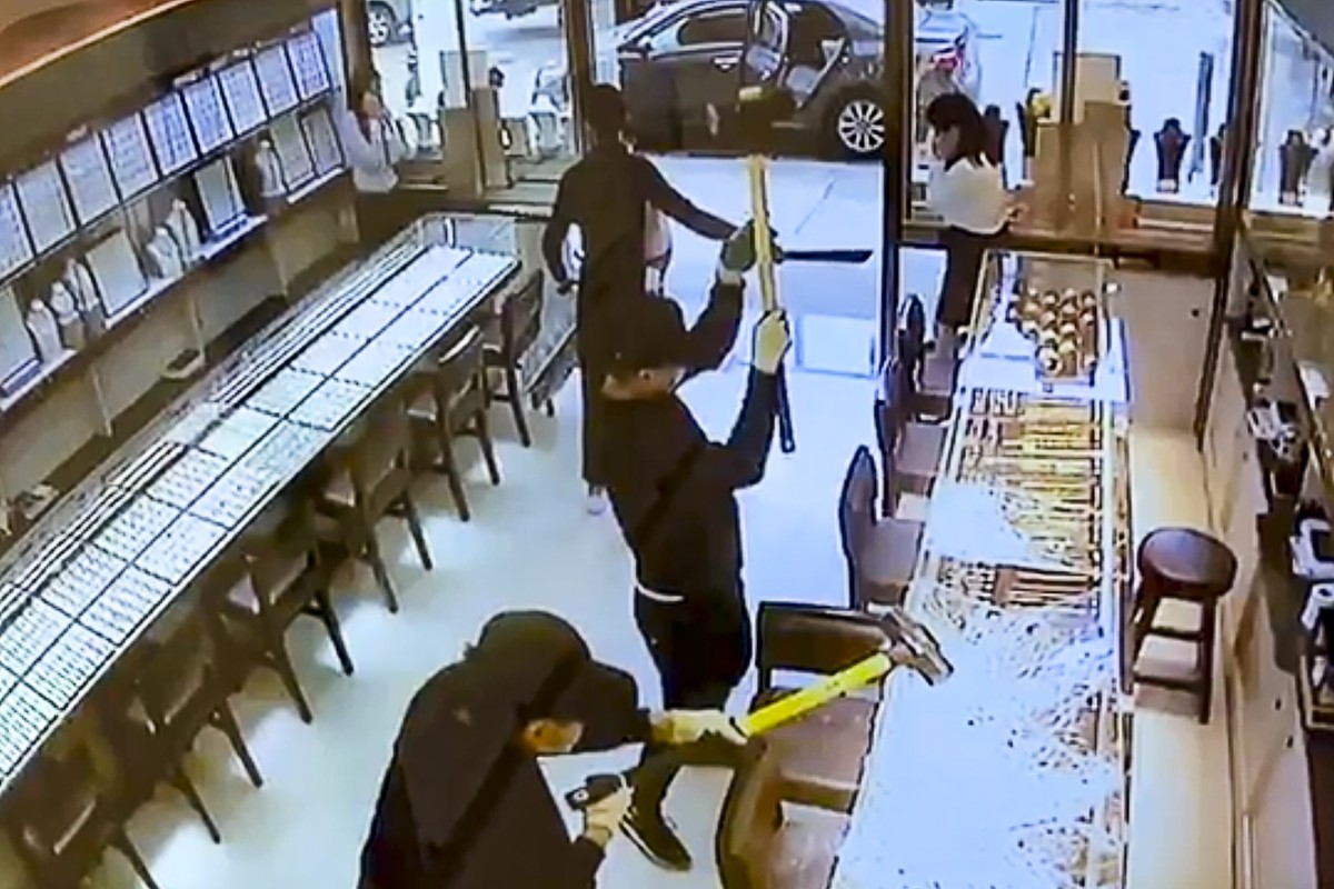 Two men go to work on a jewellery counter with sledgehammers as an accomplice holds staff at bay with a knife during a robbery. Photo: Facebook
