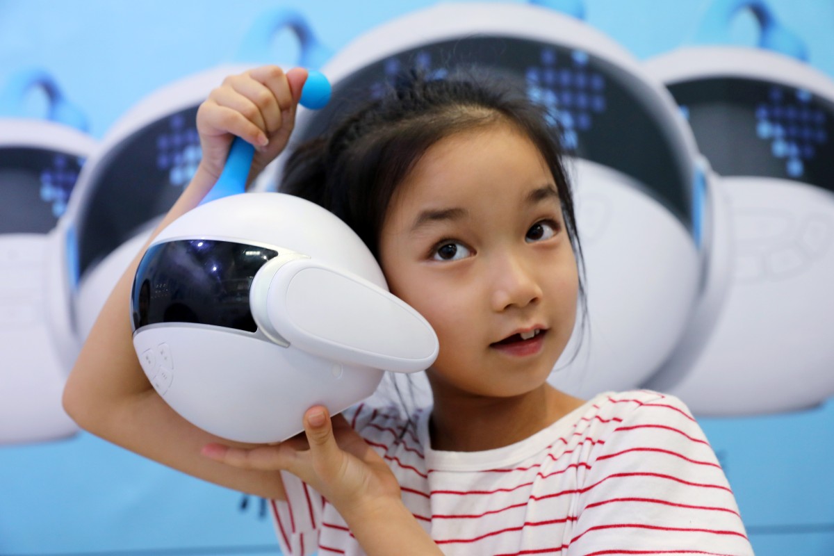A girl plays with a robot designed to be a growing partner for kids at the 2018 Smart China Expo in Chongqing on August 23, 2018. Photo: Simon Song
