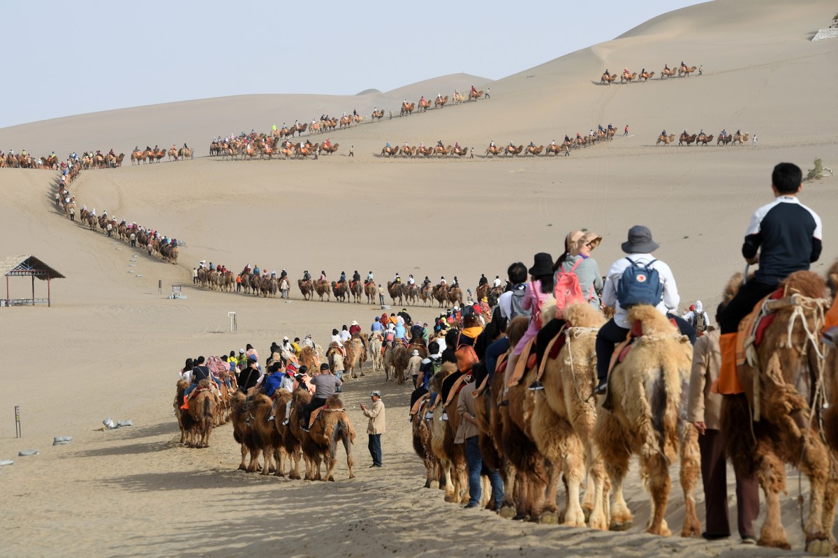 Tourists ride camels in the Crescent Spring and Mingsha Sand Dune scenic area in Dunhuang, northwest China’s Gansu province, last year. Photo: Xinhua