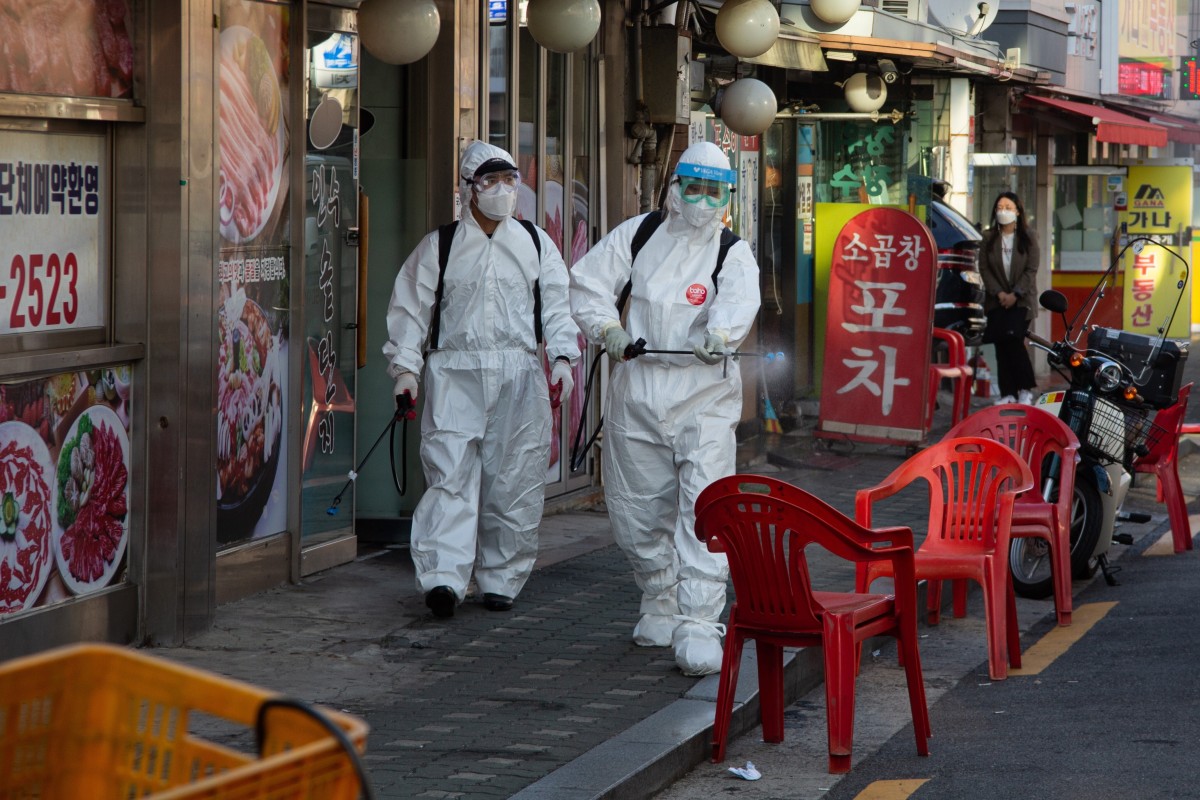 South Korean workers spray disinfectant in a street in Seoul. Photo: EPA-EFE