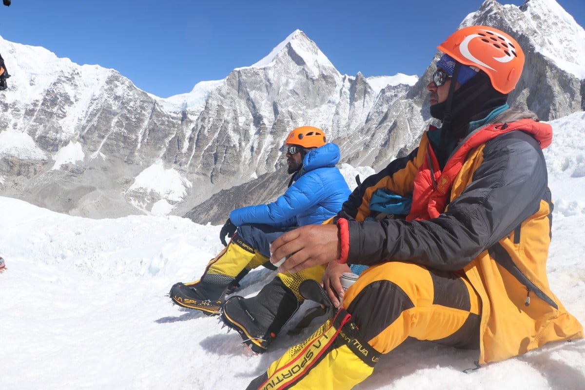 Khim Lal Gautam (front) rests on the snow with a member of his team on the way to summit Mount Everest.