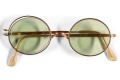 The glasses feature round, green-tinted lenses and a golden frame. Photo: Sotheby's