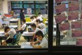 Primary school students in a Wan Chai school pray for the Covid-19 pandemic to ease before class on June 8. Photo: Nora Tam