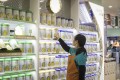 An employee arranges cans of infant milk powder inside a store in Shanghai. Photo: Bloomberg