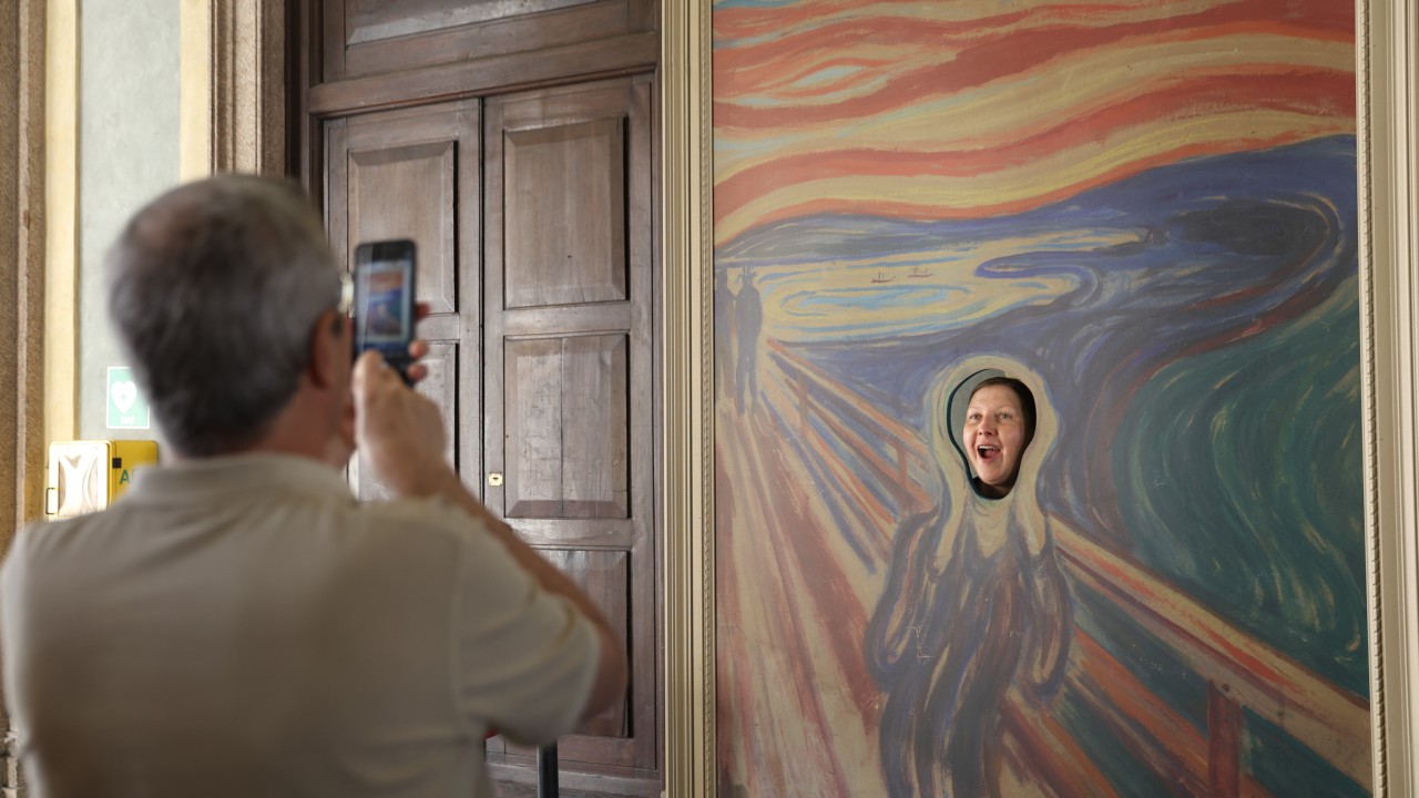 Write a funny caption for this woman having some fun at an art exhibit