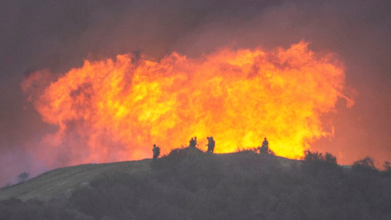 Firefighters race to contain Los Angeles wildfires before menacing winds return