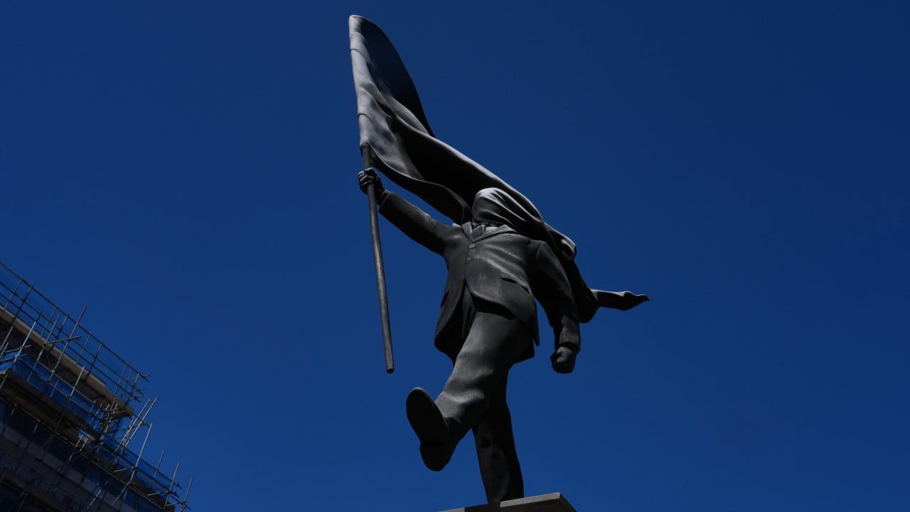 New Banksy statue of man blinded by flag draws crowds in London