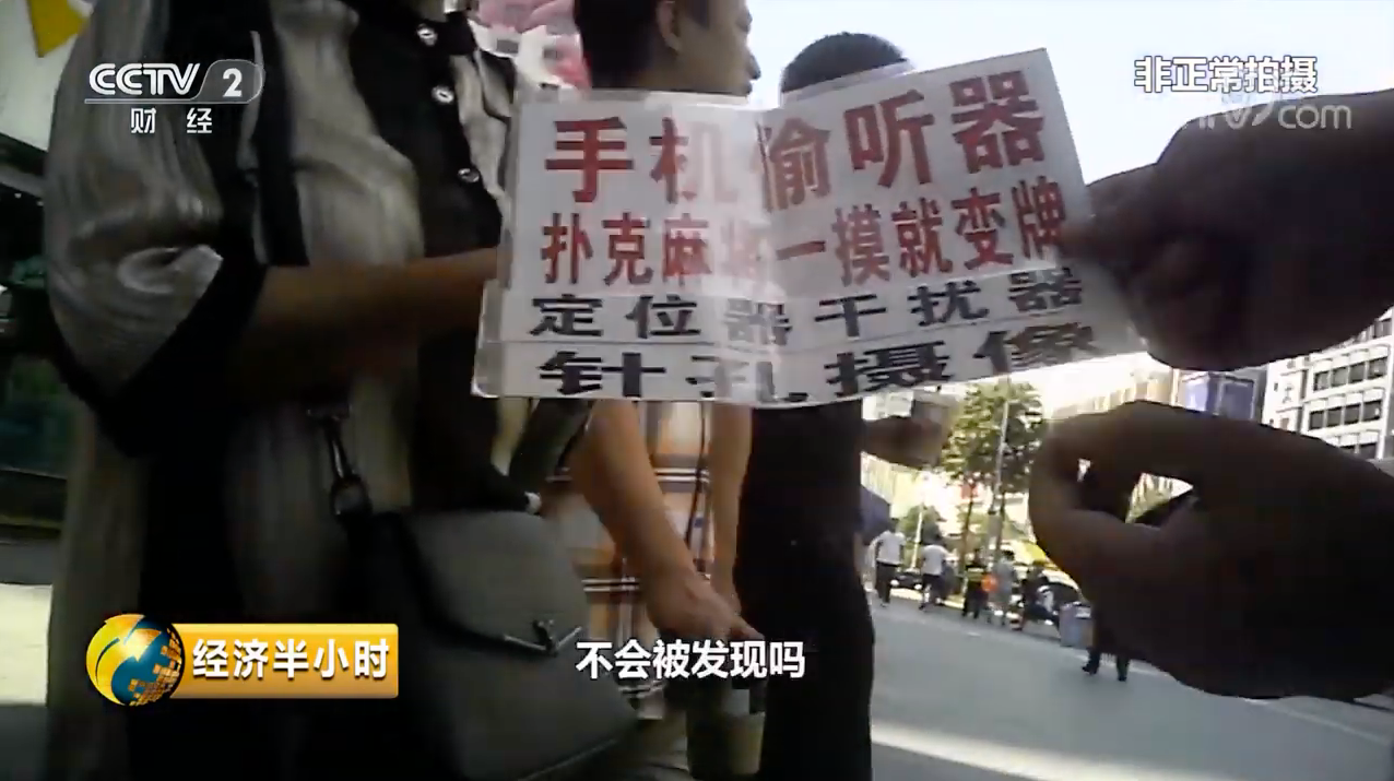 The reporter came across at least half a dozen sellers holding signs advertising spy equipment for sale. (Picture: CCTV)