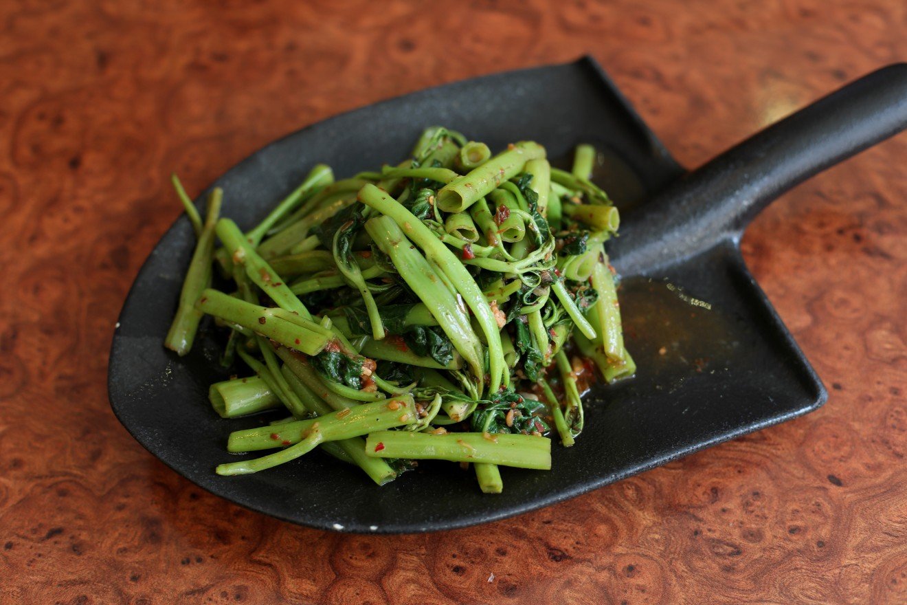 Épinards d'eau chinois sautés avec du chili et de la pâte de crevettes. (Oui, c'est une assiette en forme de pelle.)