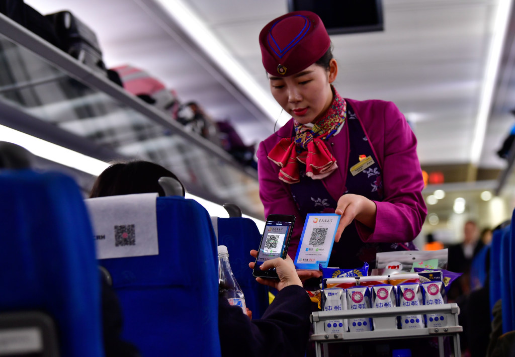 A passenger buys a bottle of water with a smartphone app on a Chinese train. (Picture: Liu Chuan/Xinhua)