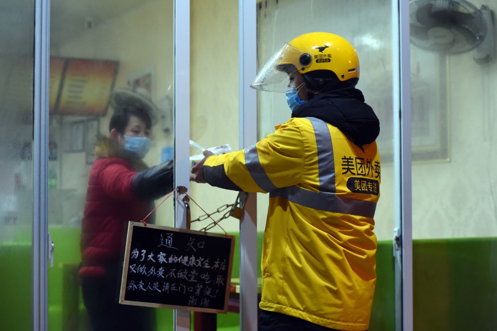 A food delivery worker for Meituan picks up a delivery from a restaurant in Hefei, in eastern China's Anhui Province, in February.(Picture: Xinhua)