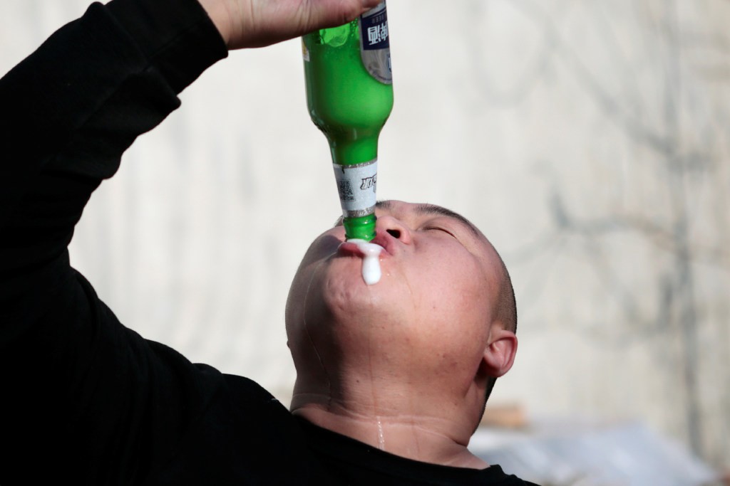 Liu Shichao, known as Hebei Pangzai or "Fatty" on social media, performs beer-drinking with a "tornado" in the bottle in Hebei province in December 2019. (Picture: Reuters)