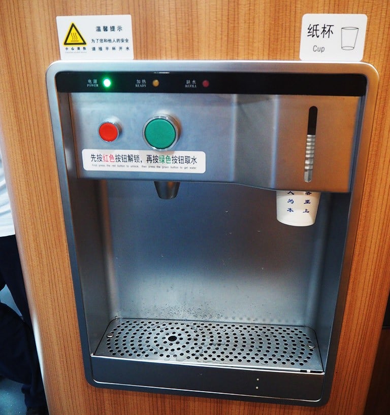 A hot water dispenser on a train in China. The red button is a safety lock, while the green is for dispensing hot water.