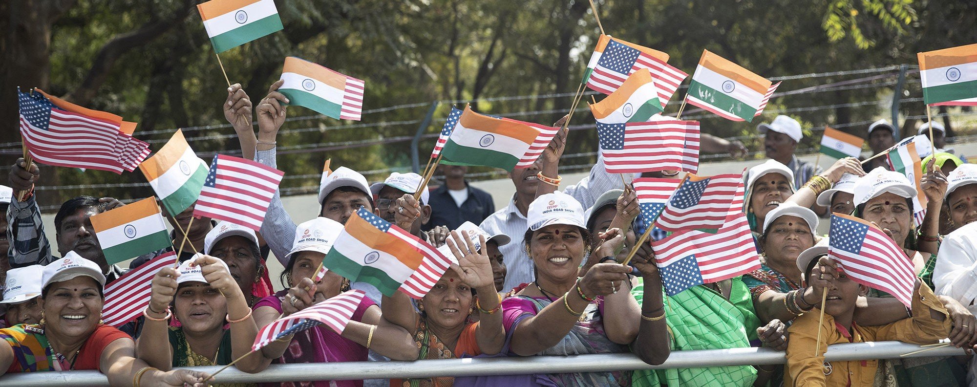 People line the street and wave flags as a motorcade for President Donald Trump passes by in Ahmedabad, India. Photo: AP