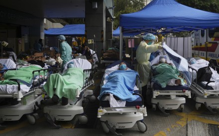 Patients lie on hospital beds as they wait at a temporary makeshift treatment area outside the Caritas Medical Centre during Hong Kong’s Covid-19 fifth wave in February 2022. Photo: AP