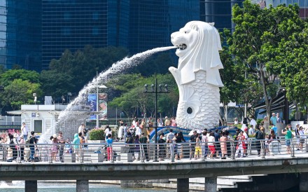 Tourists gather for photos near the Merlion statue in Singapore. More than 327,000 people arrived in the city state from China last month, official figures show. Photo: AFP