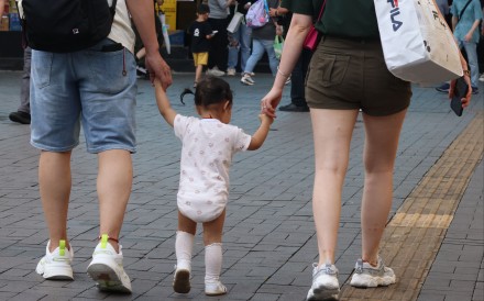 Two parents with their child pass by the Tsim Sha Tsui waterfront. The recent deaths of three girls underscore the importance of people getting inoculated against flu. Photo: Jelly Tse