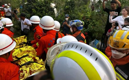 A Hong Kong rescue team carry a survivor away from the rubble of a Mandalay hotel in Myanmar. Photo: Handout