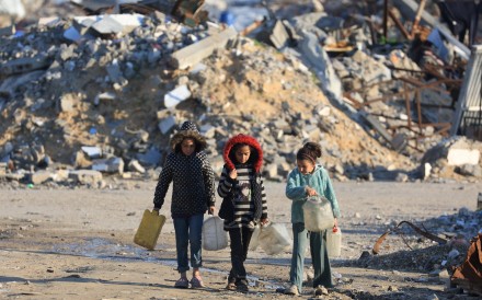 Palestinian girls walk past the rubble of residential buildings destroyed during the war in Gaza City on Friday. Photo: Reuters