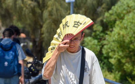 A man shades himself from the heat with a fan in Melbourne, Australia, on Tuesday. Victorians are sweating through what could be the state’s most severe heatwave in nearly two decades. Photo: EPA