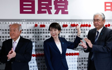 Japanese Prime Minister Sanae Takaichi (centre), leader of Japan’s ruling Liberal Democratic Party, places flowers symbolising success onto the names of candidates at the party’s headquarters in Tokyo on February 8, 2026. Photo: Xinhua