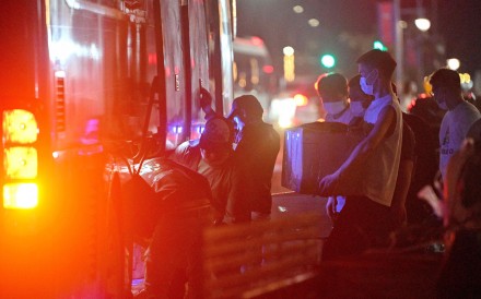 People carry their belongings onto a bus as they leave a suspected scam centre compound in Sihanoukville, Cambodia, last month. Photo: AFP