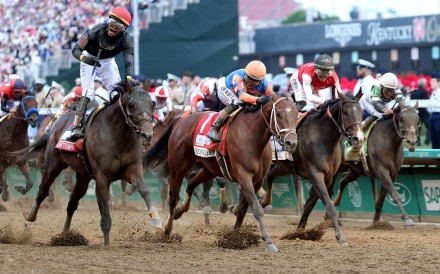 Golden Tempo (left), ridden by jockey Jose Ortiz, crosses the finish line to win the 152nd Kentucky Derby. Photo: Getty Images