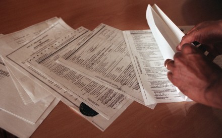 An applicant looks through H-1B visa application documents. Last year, Washington raised the H-1B application fee to US$100,000. Photo: Bay Area News Group/TNS