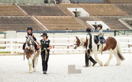 Children as young as three can ride ponies, guided by equestrian coaches, at Pony World. Photo: Alexander Mak
