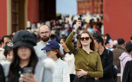 A foreign tourist records with a Chinese-brand pocket camera at the Temple of Heaven Park in Beijing on May 2. Photo: Xinhua
