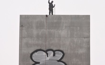 A man gestures from the top of the eastern pylon of the Bolte Bridge in Melbourne on Tuesday. Photo: EPA